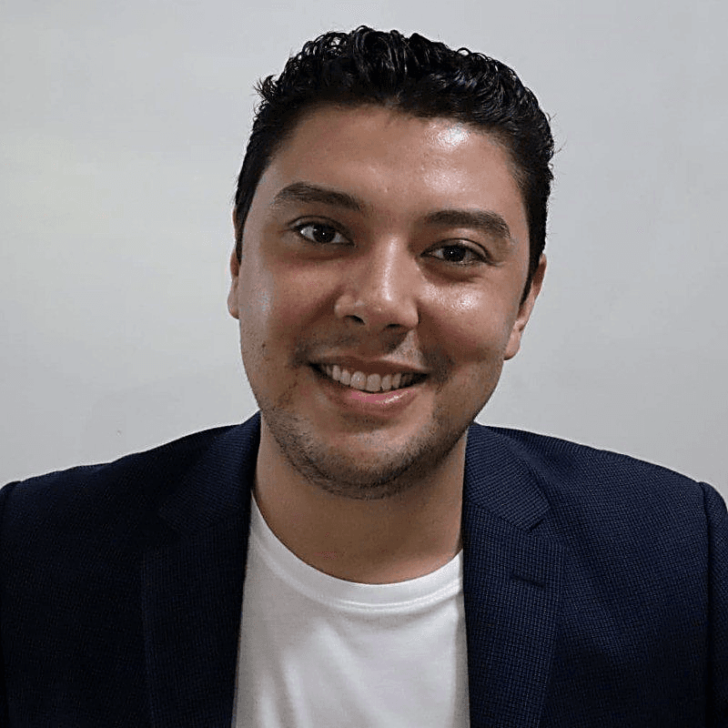 Thales, founder of Gamatauri, smiling in a navy blazer over a white shirt
