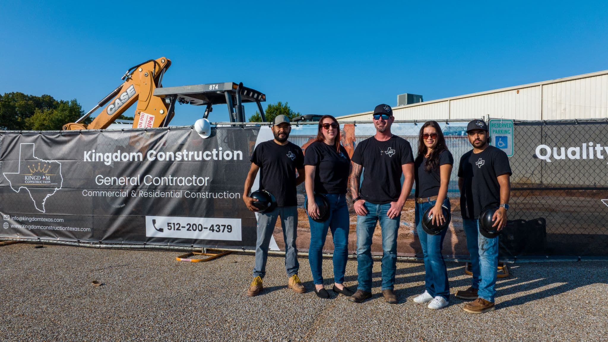 Kevin and the Kingdom Construction team in front of their jobsite banner in Texas