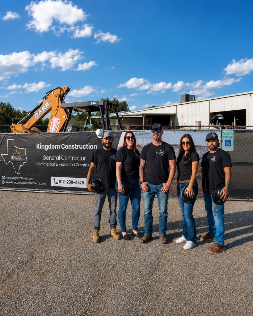 Kevin and the Kingdom Construction team in front of their jobsite banner in Texas